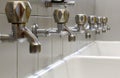 Taps lined up and a white ceramic washbasin