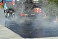 Tar truck vehicle tarring a piece of new road Royalty Free Stock Photo