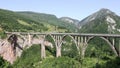 Tara canyon bridge Durdevica above Tara river Montenegro. Cars drive by bridge Tara canyon. Strong winde. Locked down