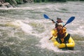 Young couple enjoy white water kayaking on the river