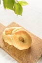 Homemade sweet tarallini is in wooden cutten board with spring twig