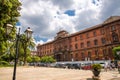 Taranto, Italy - May 7, 2018: Square of Giardini Piazza Garibaldi and old building, street lights, palm trees in front of blue sky Royalty Free Stock Photo