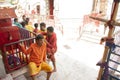 priests and devotees idly resting under the shade from scorching heat of sunlight outside at the temple premises
