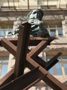 A modern sculpture of iron beams and a young Taras Shevchenko holding a book of poems