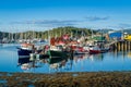 Tarbert harbor with colorful fisherman`s boats and sailing yachts docked.