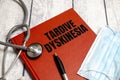 Tardive Dyskinesia - Diagnosis written on red diary with stethoscope