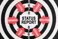 On the target, arrows with business lettering point to the center on a business card with the inscription - STATUS REPORT