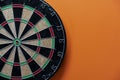 Target dart board on the table with orange background, center point, head to target marketing and business success concept