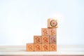 Target icon on wooden cube blocks on top of bar graph chart steps with rising percentage symbol. Royalty Free Stock Photo