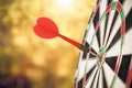 Target red arrow center of dartboard blurred bokeh background.