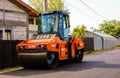 Targoviste, Romania - 2019. Orange road roller pressing the hot asphalt. Construction of a new road with support from the European