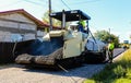 Targoviste, Romania - 2019. Workers operating asphalt paver machine during road construction. Construction of a new road with