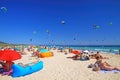 Spanish beach scene with people sunbathing, kite surfers, atlantic ocean waves, clear blue sky