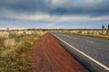 Tarmac road lead to nowhere in Australian desert in stormy cloud Royalty Free Stock Photo