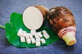Taro root with half and slice cubes on taro leaf and wooden background, Fresh raw organic taro root ready to cook Royalty Free Stock Photo