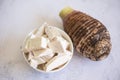 Taro root with slice cubes on bowl and table background, Fresh raw organic taro root ready to cook Royalty Free Stock Photo