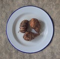 Fresh small baby taro yam with roots and soil on enamelware plate