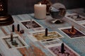 A tarot card reading session depicted with candles, crystals, and mystical accessories on a rustic wooden table. Royalty Free Stock Photo