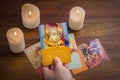 tarot cards and burning candle on wooden table