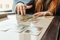 Tarot cards, Tarot card divination, esoteric background. A woman makes a layout on the cards at the table. Divination