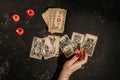 Tarot cards and female hands of fortune teller on black magic table