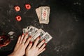 Tarot cards and female hands of fortune teller on black magic table