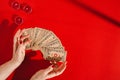 Tarot cards and female hands of fortune teller on red background