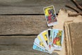 Tarot cards and old book on wooden table, flat lay. Space for text