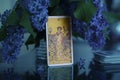 Tarot cards on the table, Nine of Coins Pentacles. Lilac bouquet.