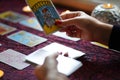 Tarot reader picking tarot cards near burning candles.