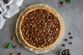 Tart with chocolate caramel, hazelnuts, peanuts, almonds and seed mix on a dark concrete background. Horizontal orientation. Royalty Free Stock Photo