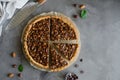 Tart with chocolate caramel, hazelnuts, peanuts, almonds and seed mix on a dark concrete background. Horizontal orientation. Royalty Free Stock Photo