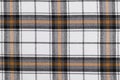 Tartan fabric texture in white, yellow and black colors. Traditional Scottish clothing. Background for your design