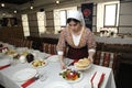 At the Tartar restaurant: waitress in Tartar native dress setting the table