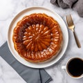 Tarte tatin, upside down apple tart on round plate on marble background, traditional french apple pie with caramelized apples on