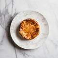 Tarte tatin, upside down apple tart on round plate on marble background, traditional french apple pie with caramelized apples, top