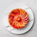 Tarte tatin, upside down apple tart on round plate on marble background, traditional french apple pie with caramelized apples on