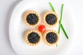 Tartlet with black caviar on a white platter Royalty Free Stock Photo