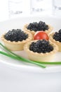 Tartlet with black caviar on a white platter