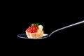 Tartlet with red caviar and butter and dill on a tablespoon on a