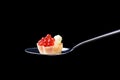 Tartlet with red caviar and butter on a tablespoon on a black ba
