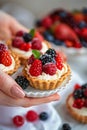 tartlets with berries in hands. Selective focus. Royalty Free Stock Photo
