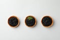 Tartlets with black caviar on white background, top view Royalty Free Stock Photo
