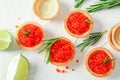 Tartlets with caviar, rosemary and limes on white background