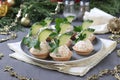 Tartlets with crab sticks, cream cheese and cucumber on a plate on grey background. Festive New Year snack. Closeup