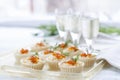 Tartlets with cream cheese and red caviar close up. Snacks with red caviar with aperitif. Light background.