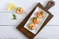 Tartlets with cream cheese and salted salmon on a white plate. Tasty light snack for a party. Finger Food.