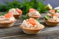 Tartlets with cream cheese and salted salmon on a wooden background. Tasty light snack for a party. Royalty Free Stock Photo