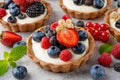 Tartlets with custard vanilla cream with fresh berries and mint on a gray concrete background. Summer dessert Royalty Free Stock Photo