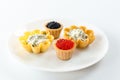 Tartlets filled with red and black caviar against rustic wooden background